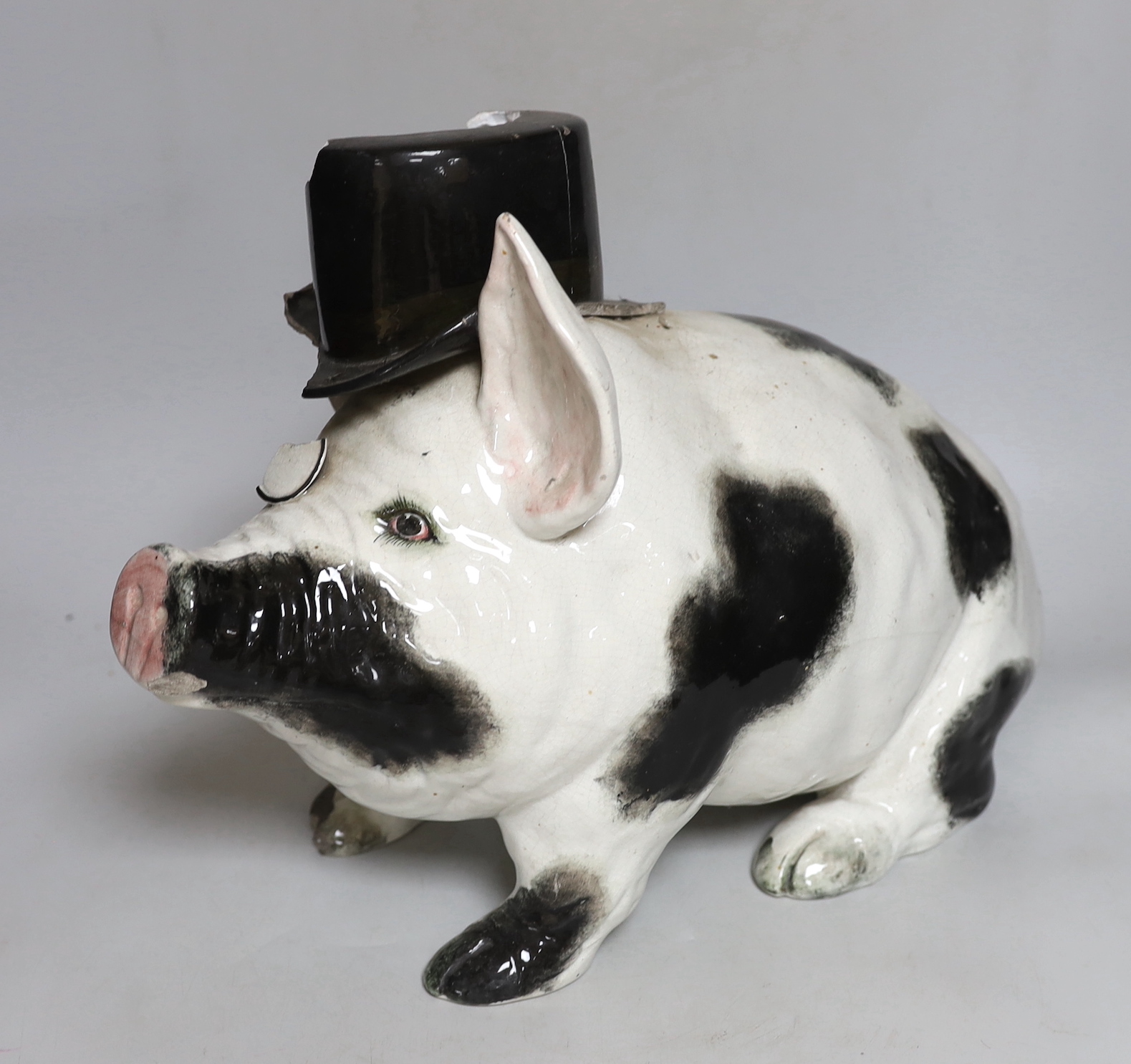 A large and rare Wemyss pig, with top hat and monocle, impressed mark WEMYSS WARE, R.H. & S, 45cm in length, a/f